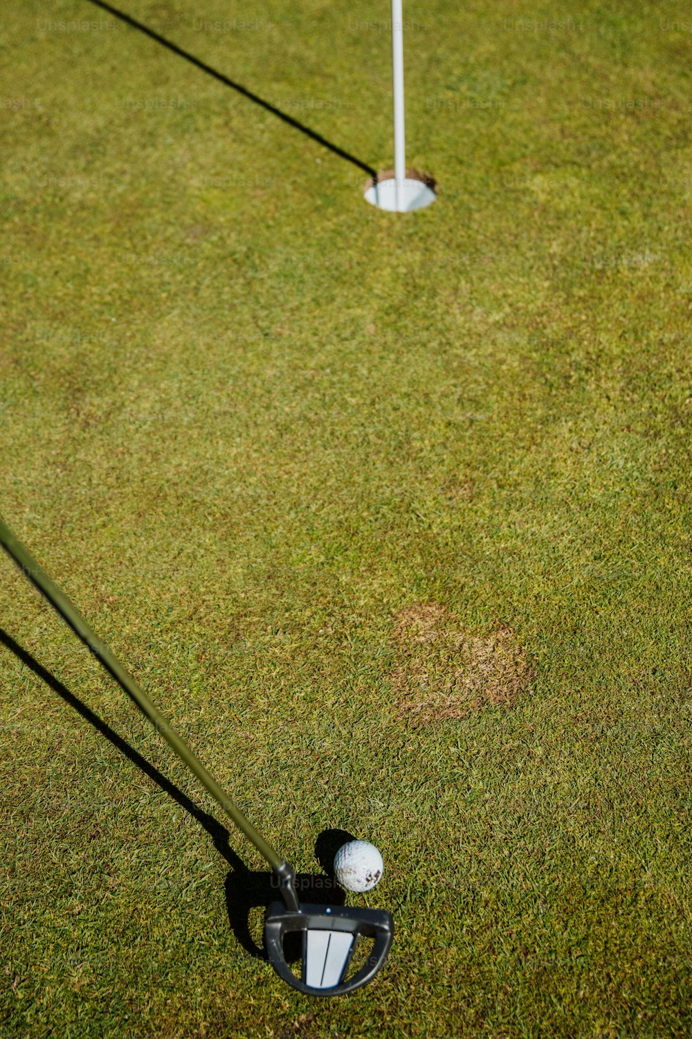 Zwei Golfschläger und ein Golfball auf dem Rasen