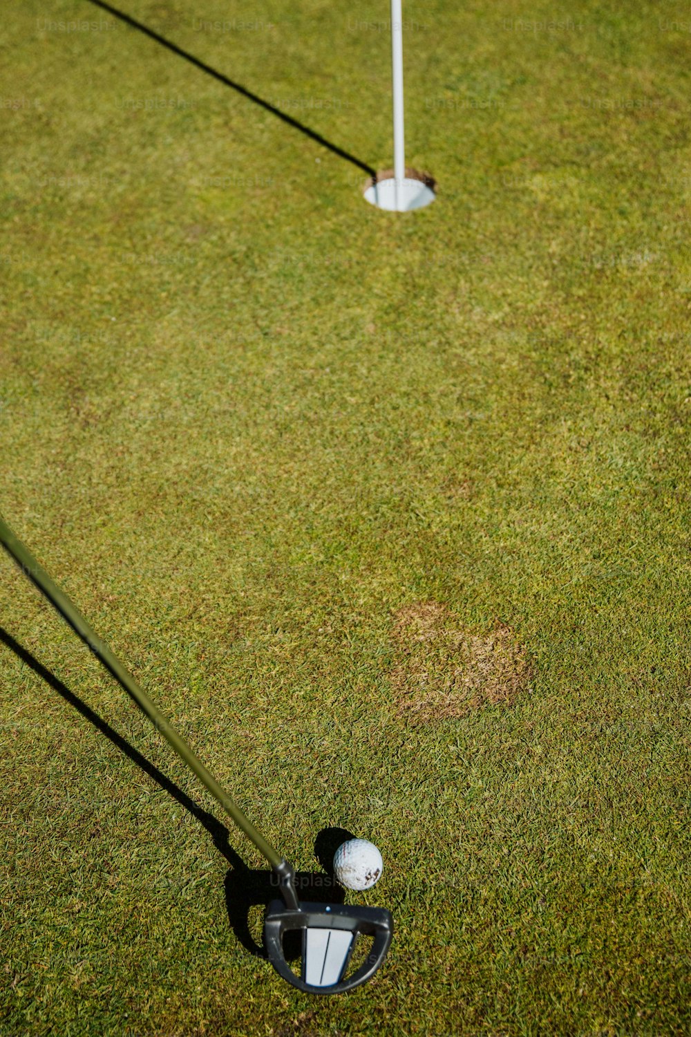 deux clubs de golf et une balle de golf sur l’herbe