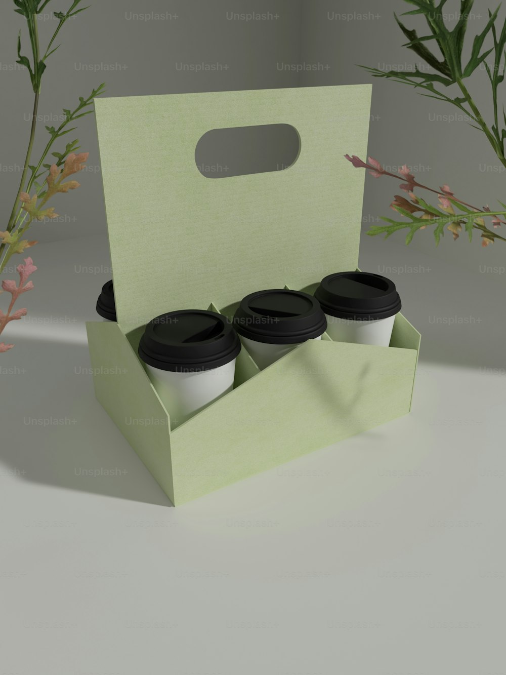 una scatola verde con tre tazze di caffè