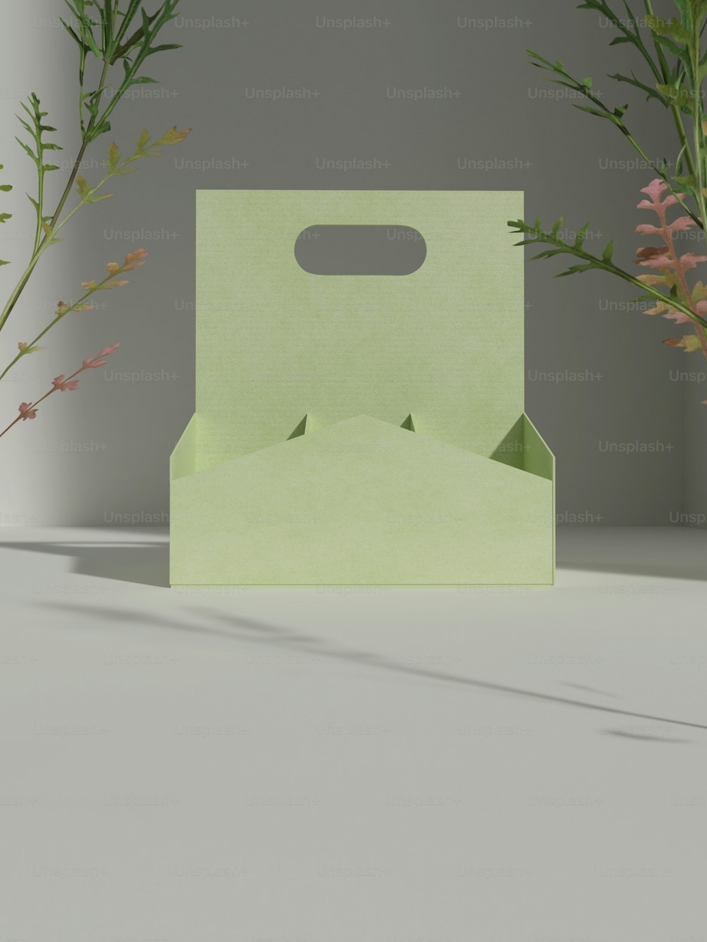 una scatola verde seduta sopra un tavolo accanto ai fiori