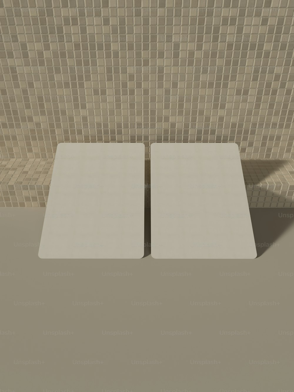 a pair of white square tables in front of a tiled wall