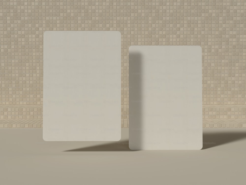 한 쌍의 흰색 사각형이 벽돌 벽 앞에 서 있습니다.