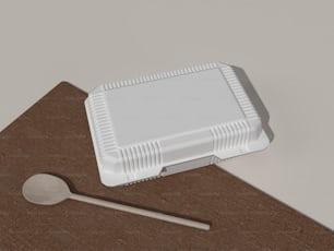 um recipiente de plástico com uma colher em uma tábua de corte