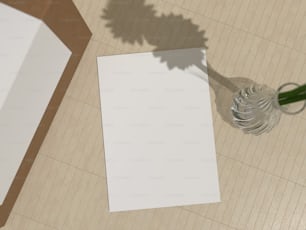 a white piece of paper sitting on top of a table next to a vase
