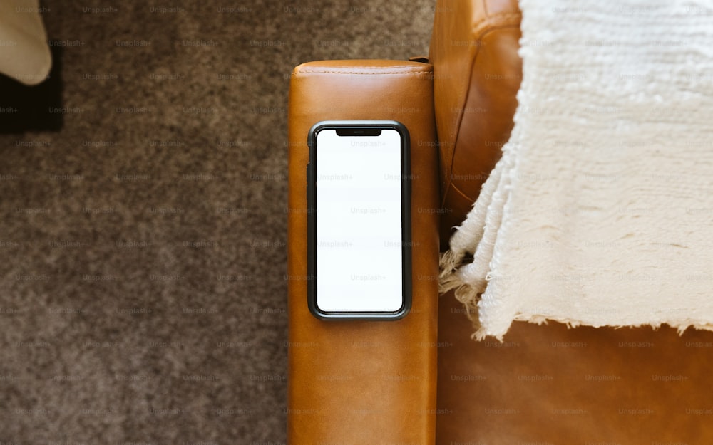 a cell phone sitting on a leather couch