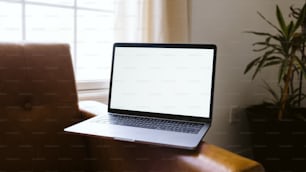 un computer portatile seduto sopra una sedia marrone