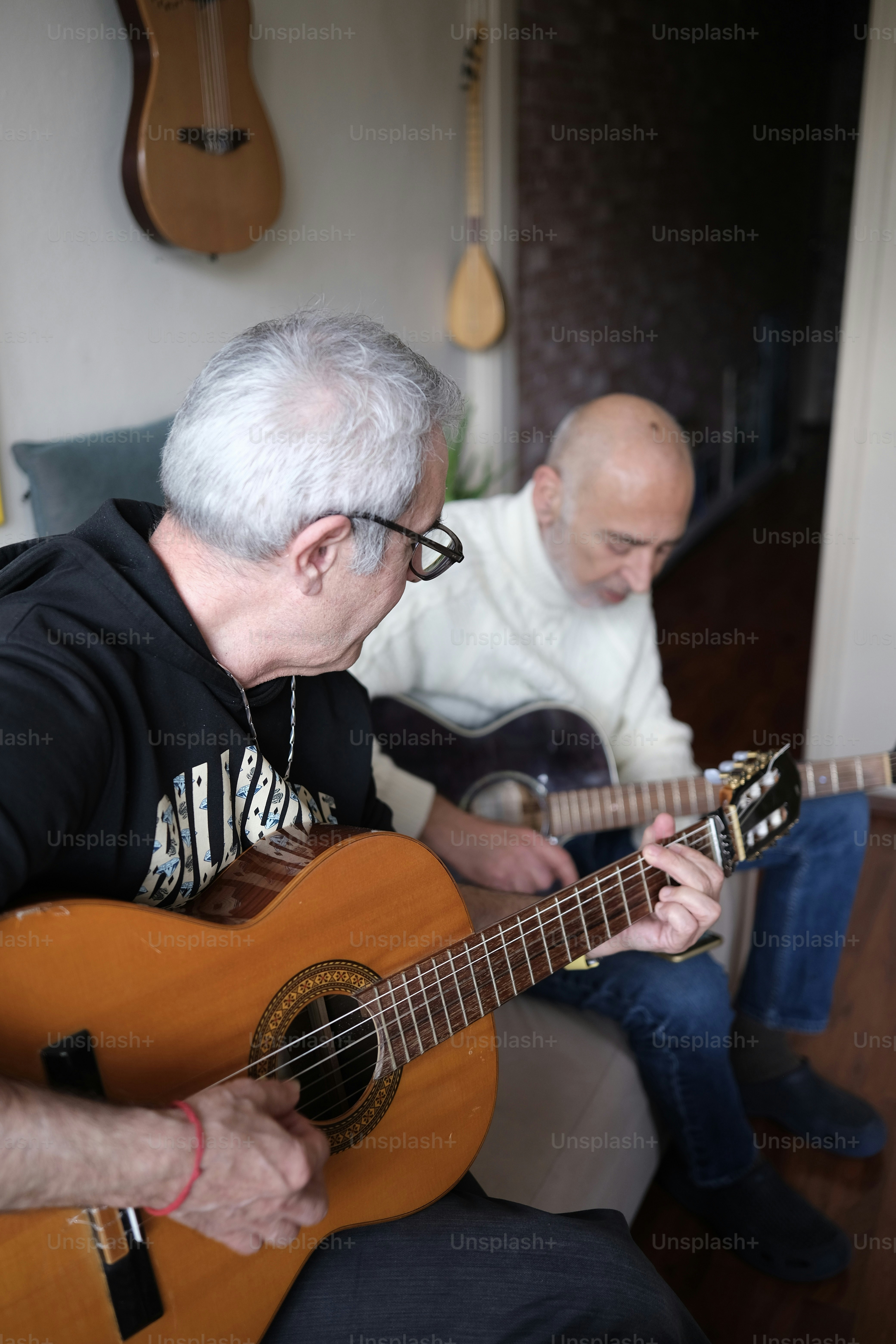 A man sitting on a couch playing a guitar photo – Music Image on Unsplash