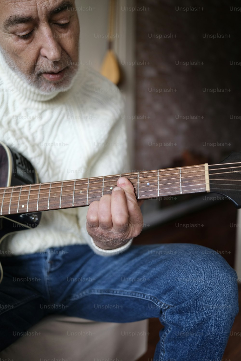 a man sitting down playing a guitar