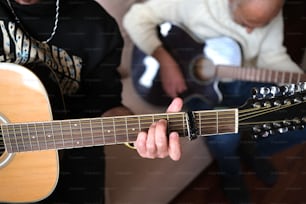 um homem tocando uma guitarra enquanto outro homem toca uma guitarra