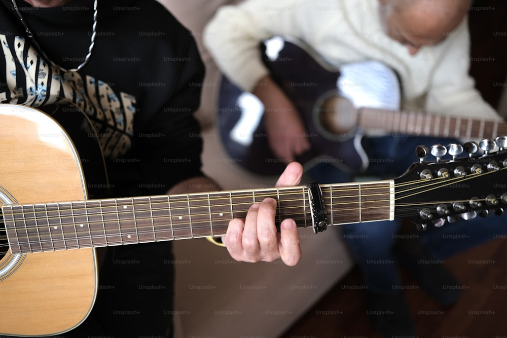 un homme jouant de la guitare tandis qu’un autre homme joue de la guitare