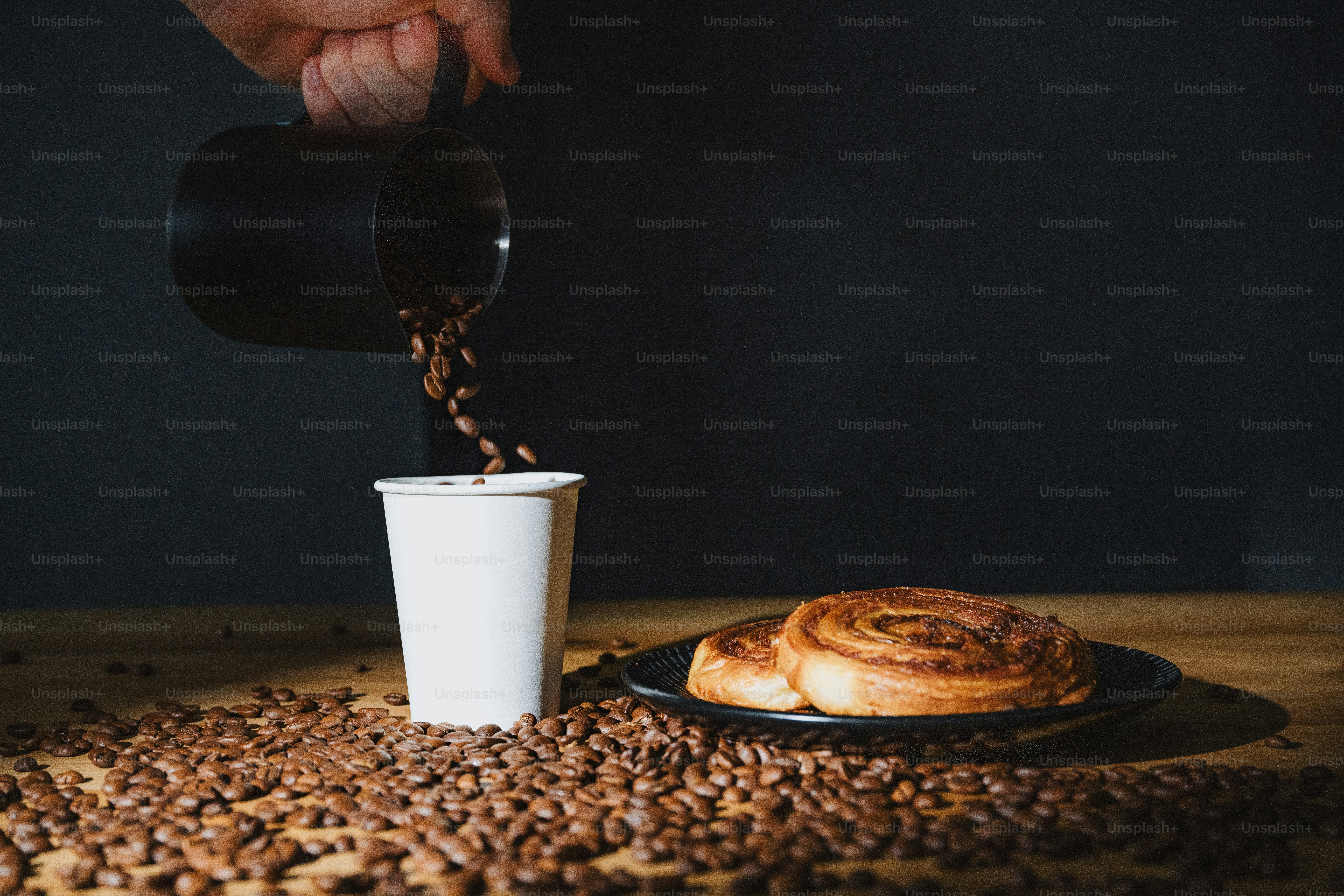 a person pouring coffee into a cup over a plate of coffee beans