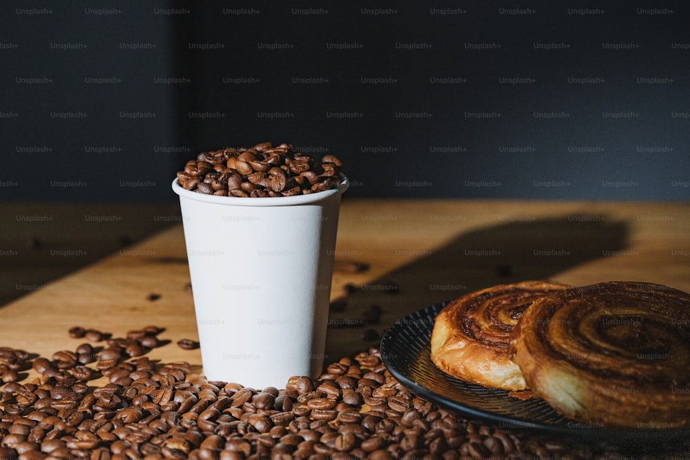 une tasse de café à côté d’une assiette de grains de café