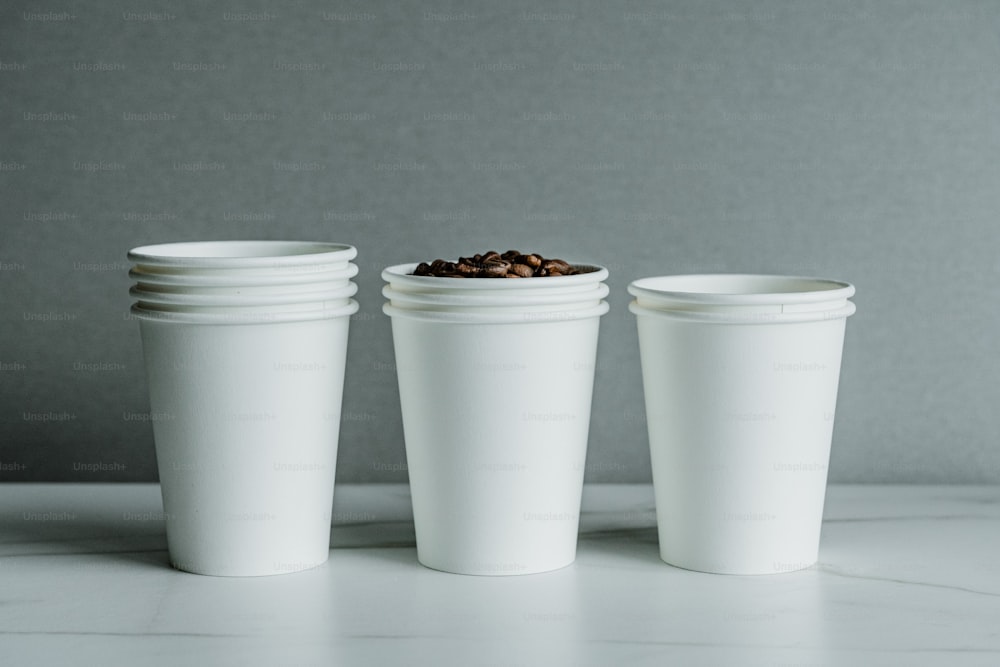 커피 원두가 들어있는 세 개의 흰색 컵
