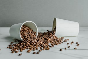 un par de tazas blancas llenas de granos de café