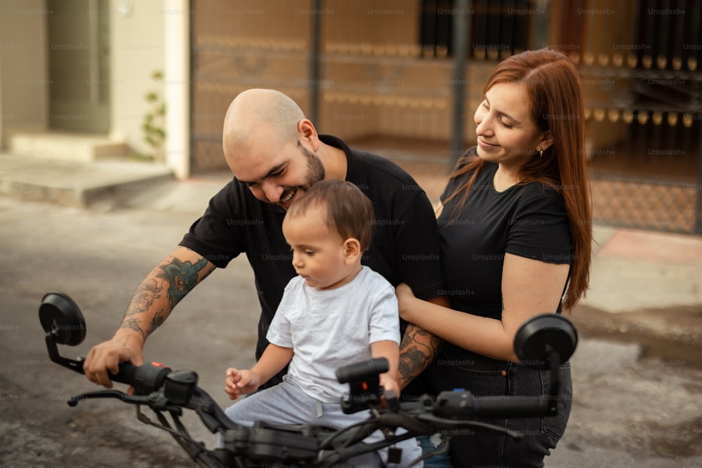 um homem, uma mulher e um bebê sentado em uma bicicleta