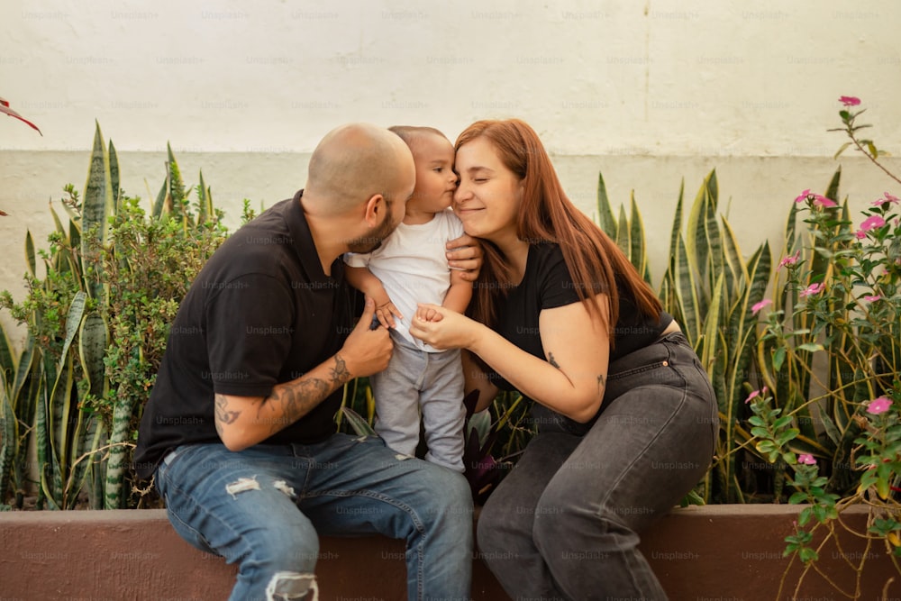 a man and a woman sitting on a bench with a baby