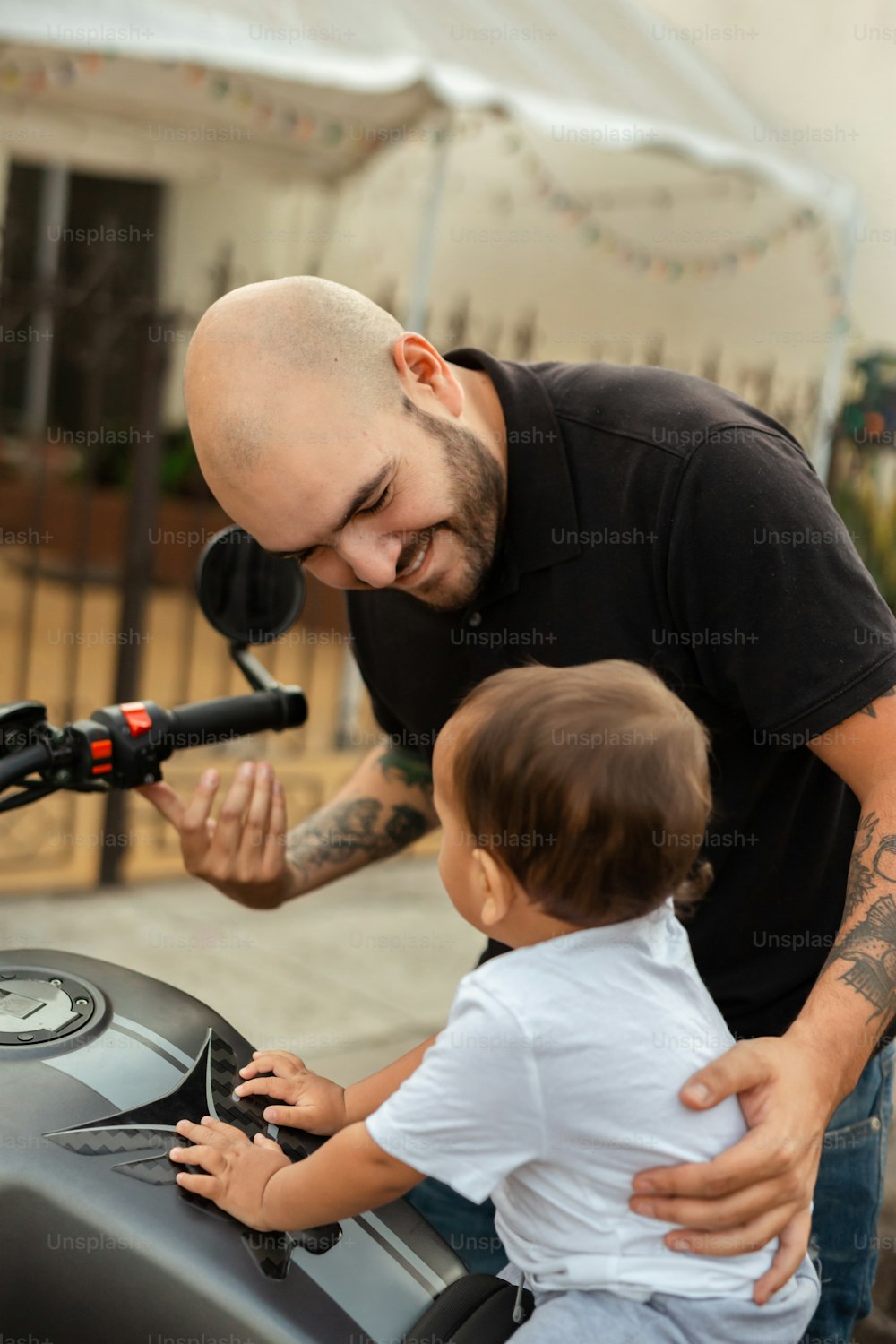 a man and a little boy standing next to a motorcycle