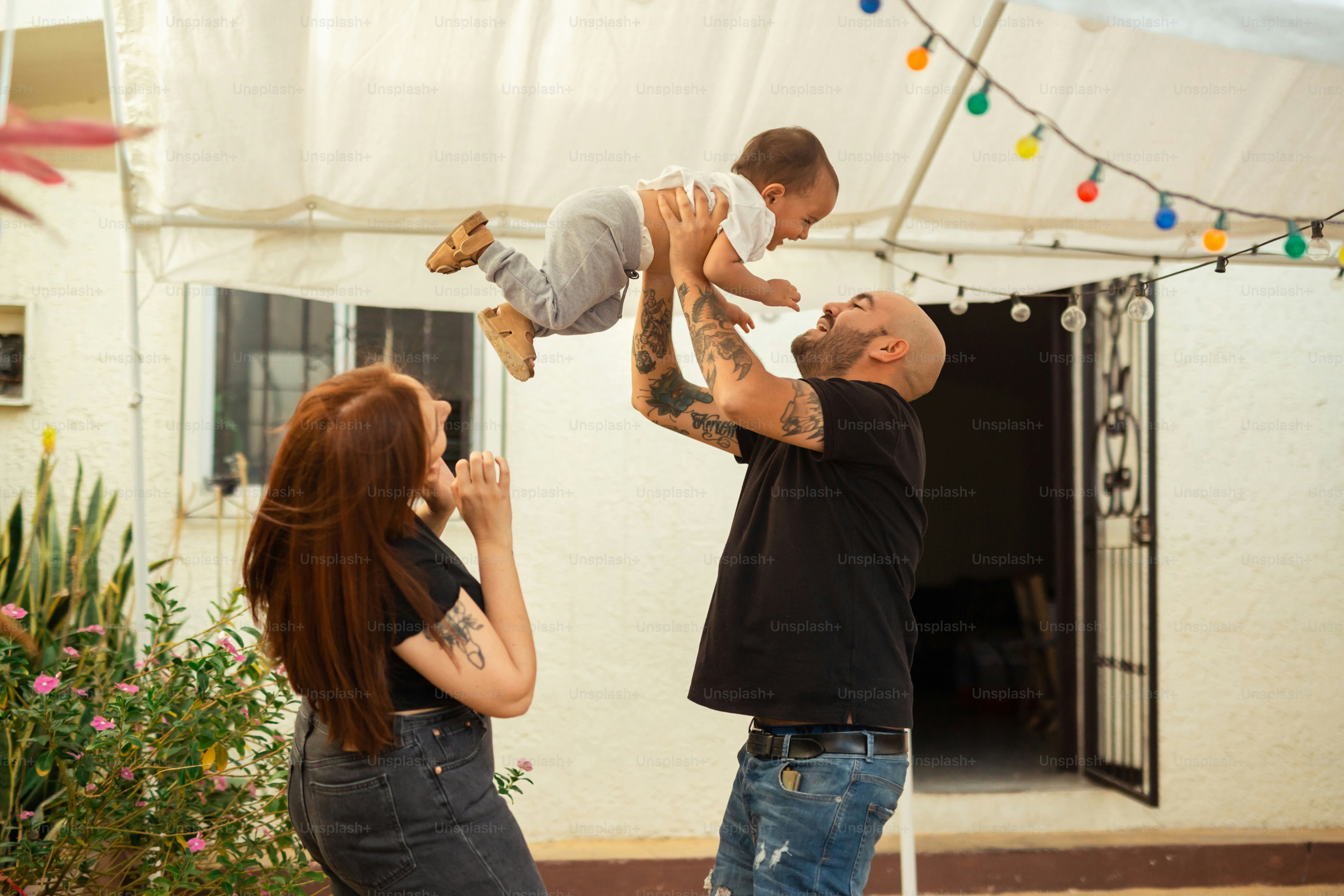 a man holding a baby up in the air