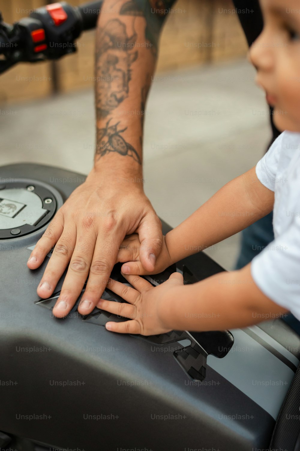 Un homme et un petit enfant touchent une moto