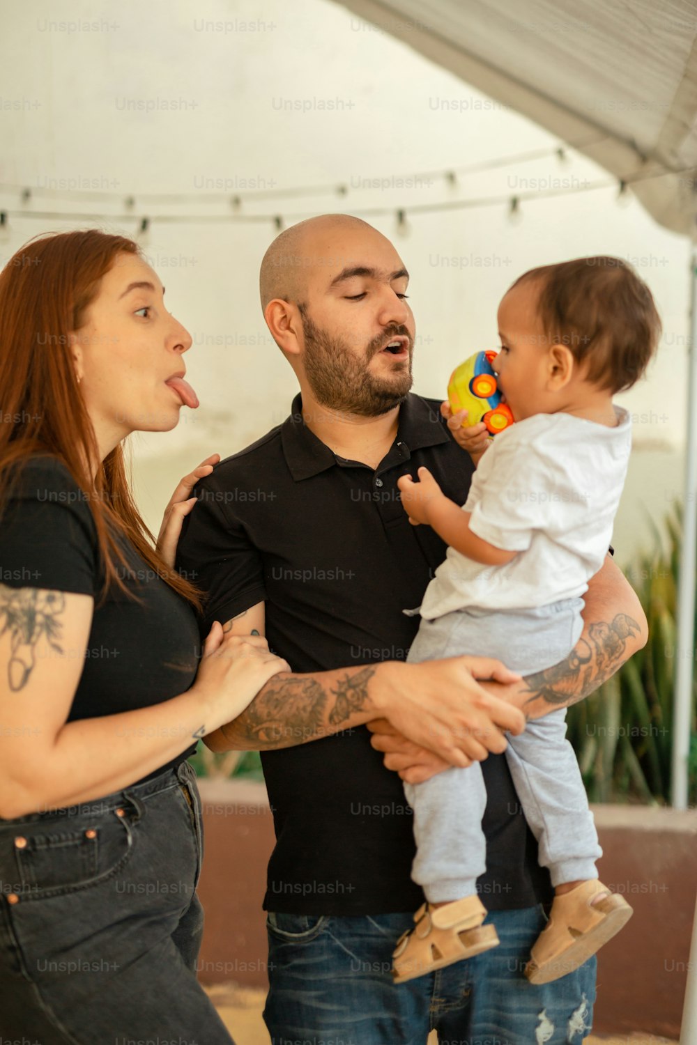 un hombre sosteniendo a un bebé y una mujer sosteniendo a un bebé