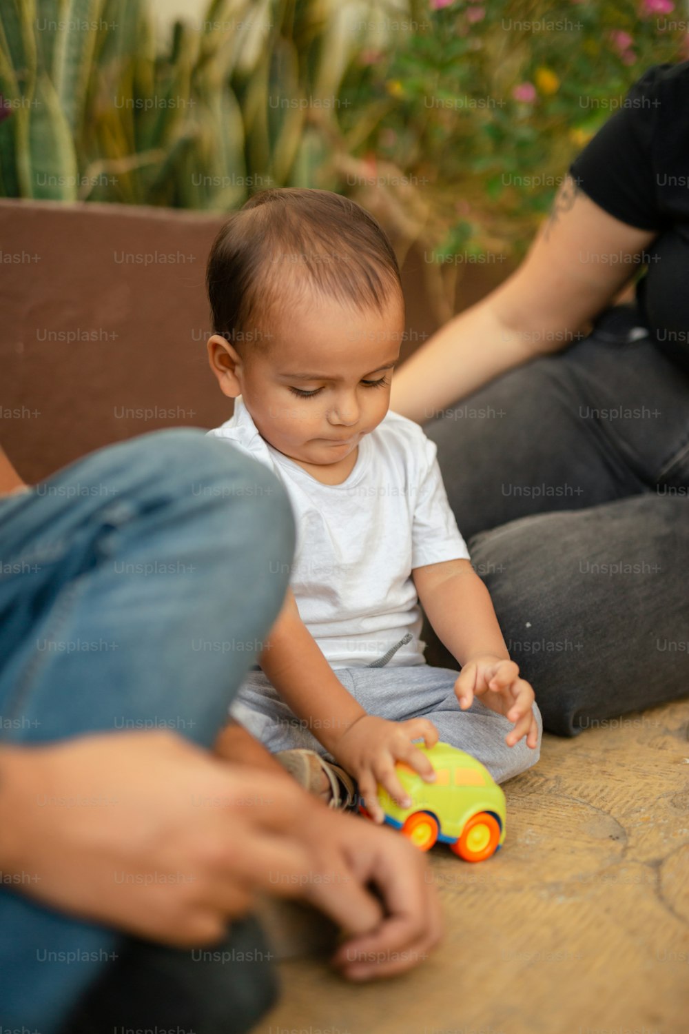 Un bebé sentado en el suelo jugando con un juguete