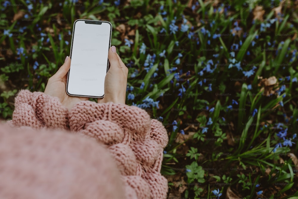 una persona sosteniendo un teléfono celular en sus manos