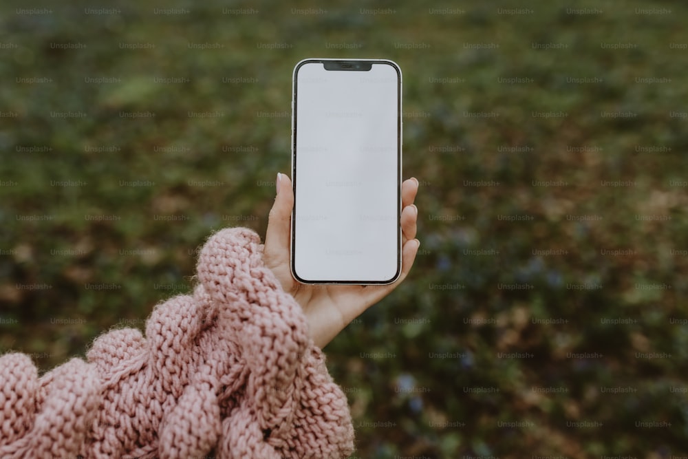 una persona sosteniendo un teléfono celular en la mano