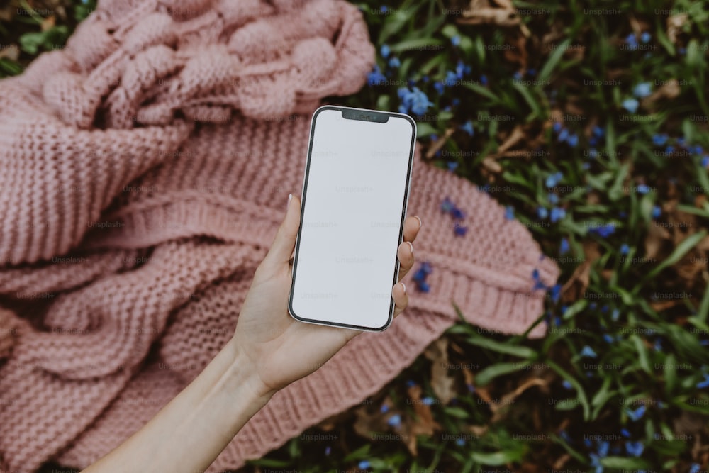 una persona sosteniendo un teléfono celular en la mano