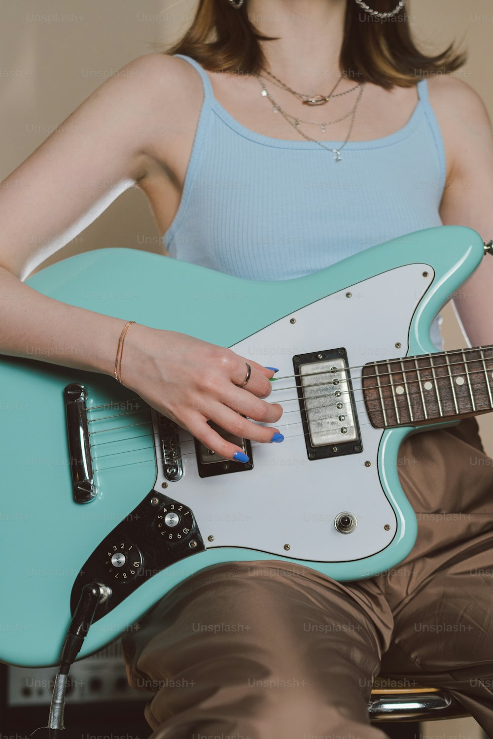 Una donna seduta su una sedia che tiene una chitarra blu