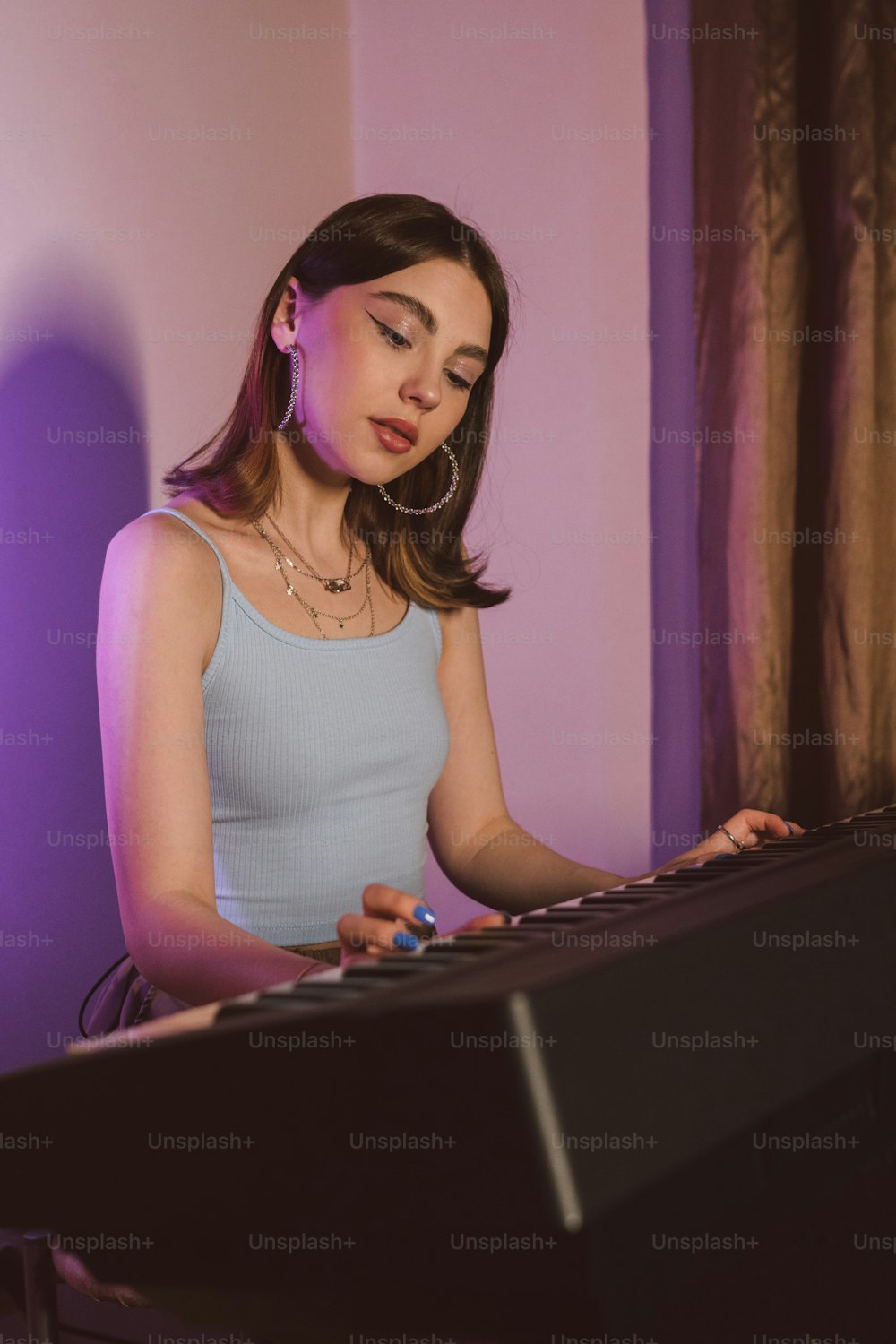 a woman sitting at a keyboard in front of a window