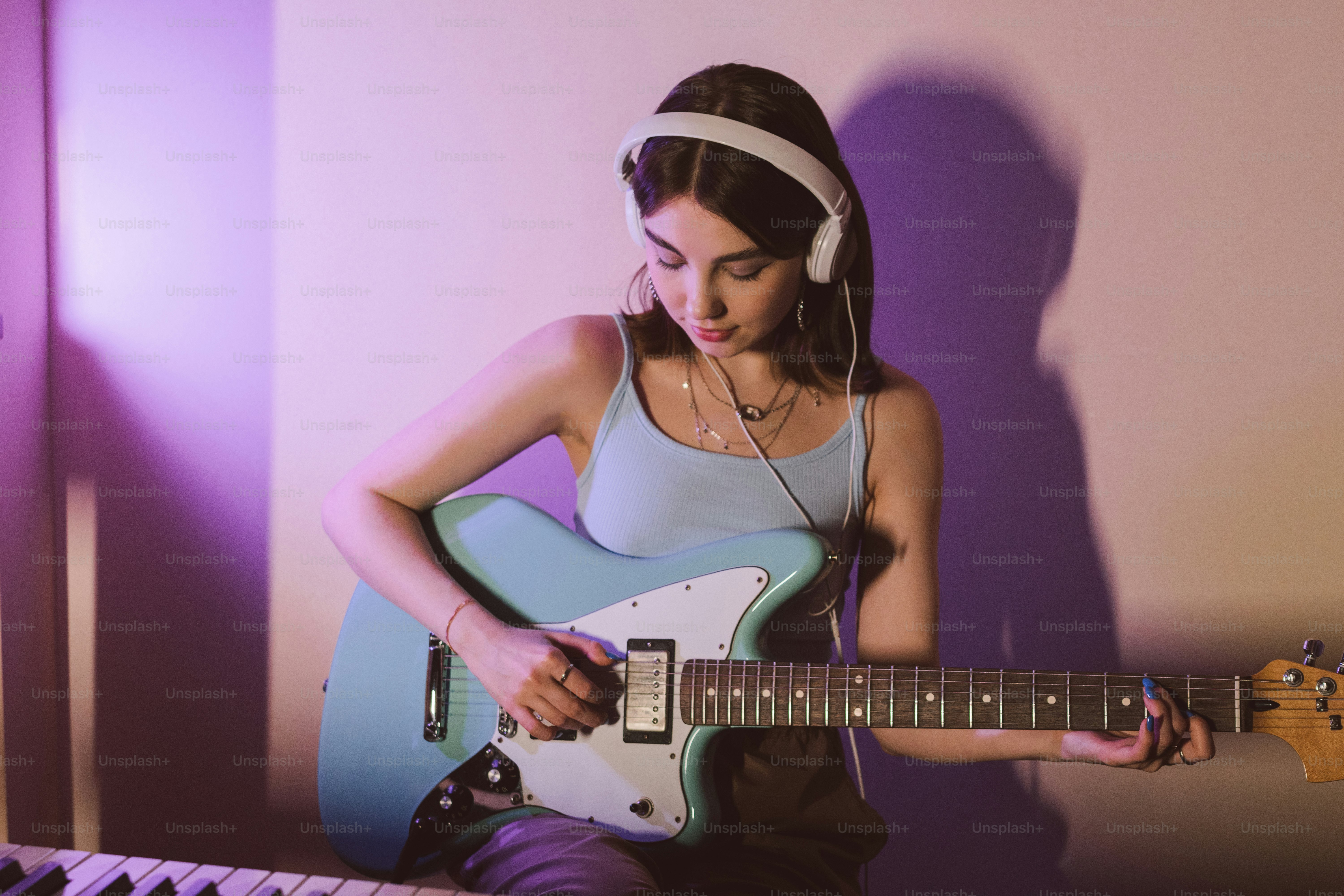 a woman with headphones playing a guitar