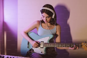 Une femme avec des écouteurs jouant de la guitare