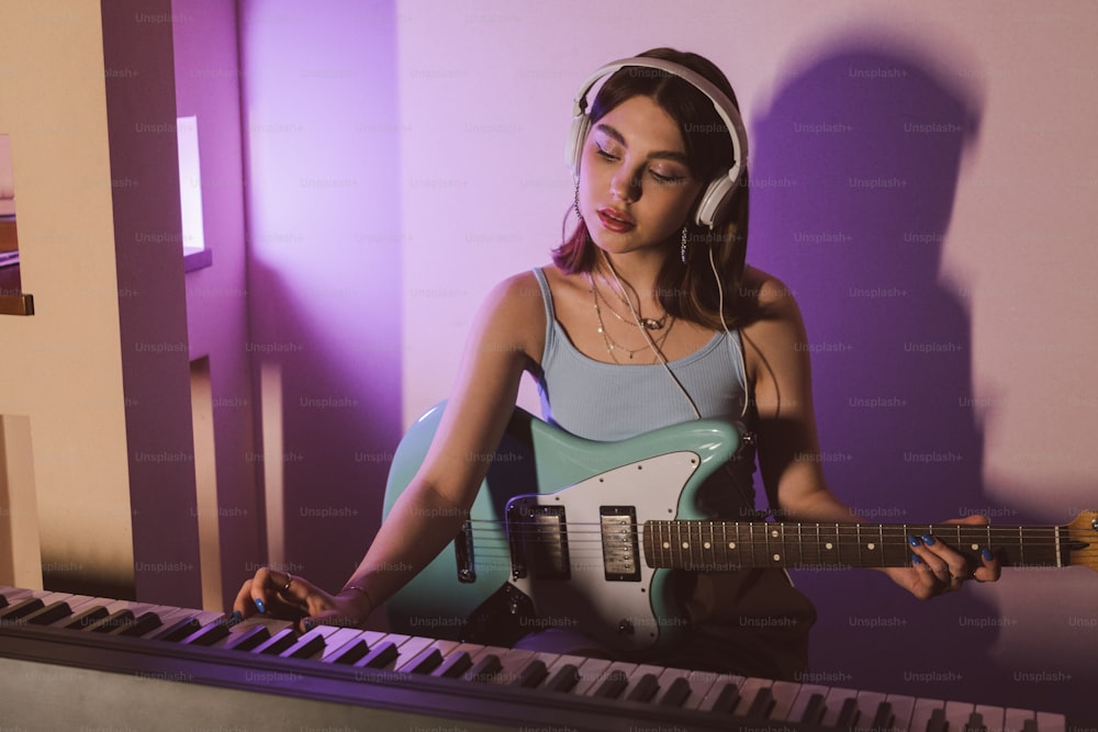 a woman with headphones playing a guitar