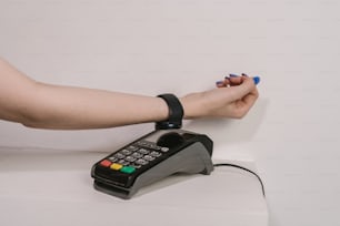 Die Hand einer Frau befindet sich auf einem Telefon, das mit einem Kabel verbunden ist