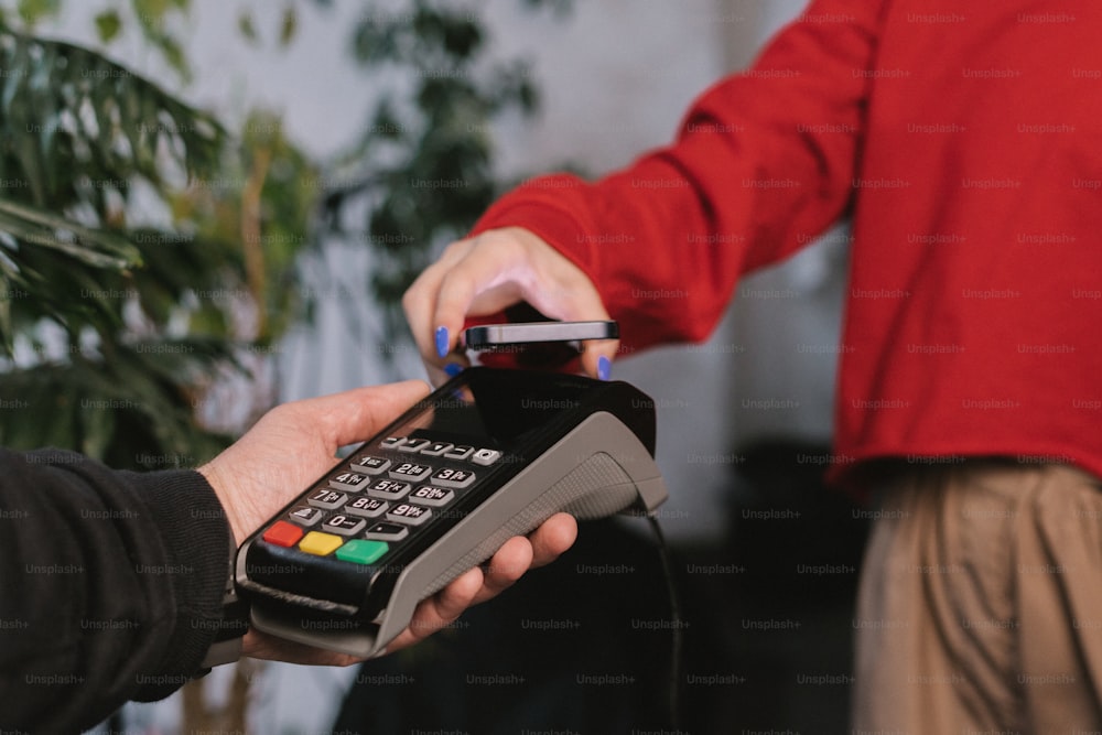 a person holding a credit card and a phone