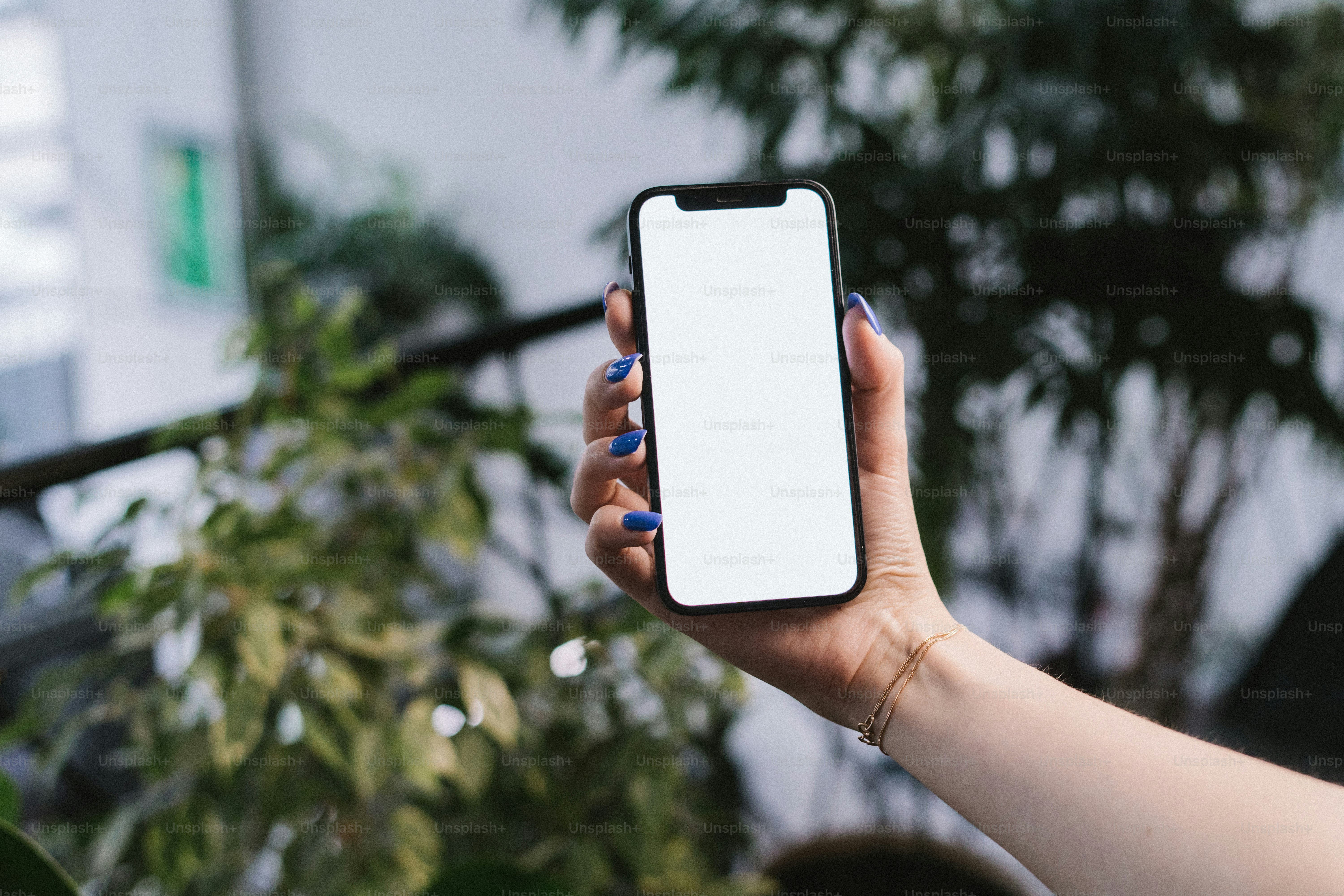 une personne tenant un téléphone cellulaire à la main