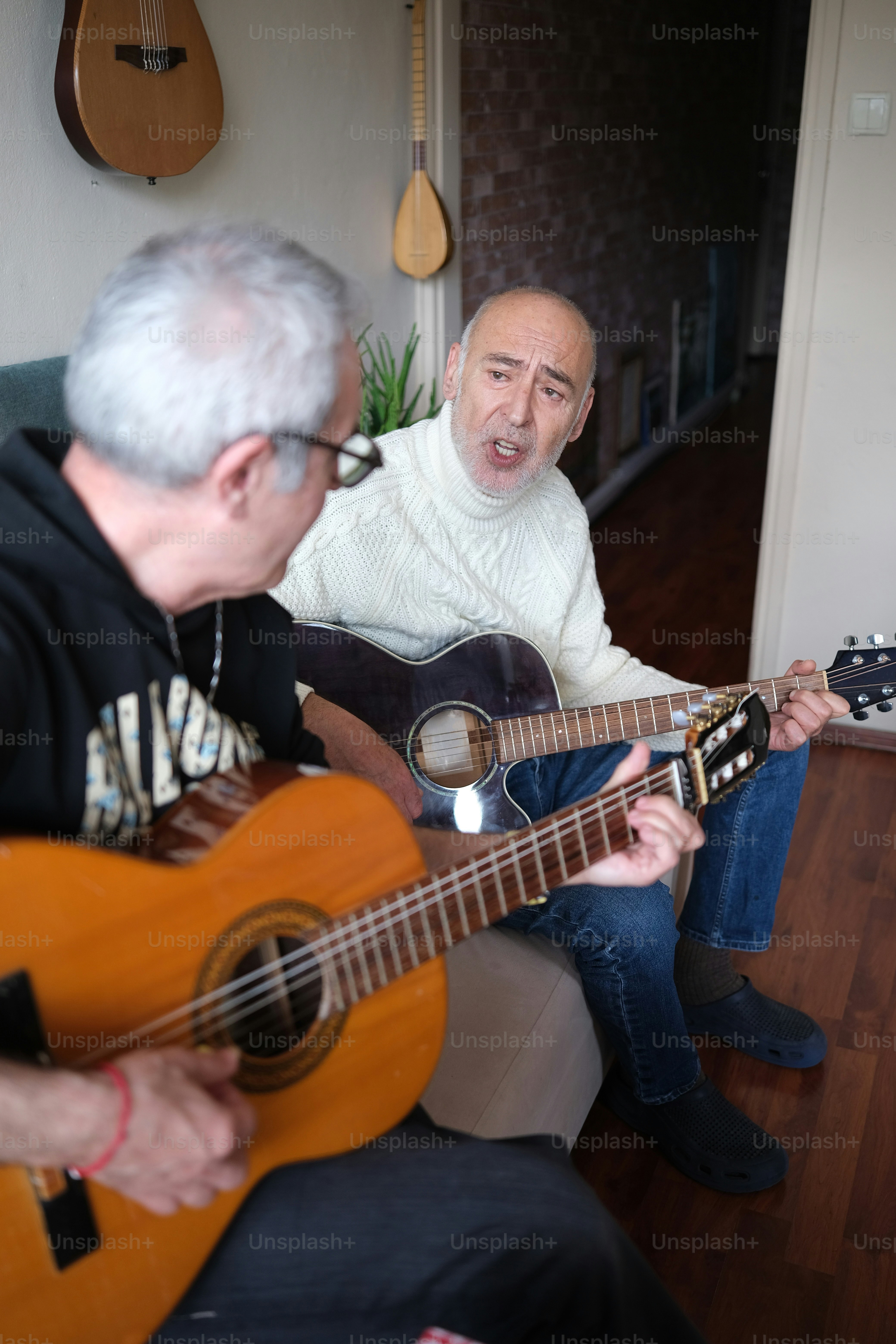 a man sitting on a couch playing a guitar