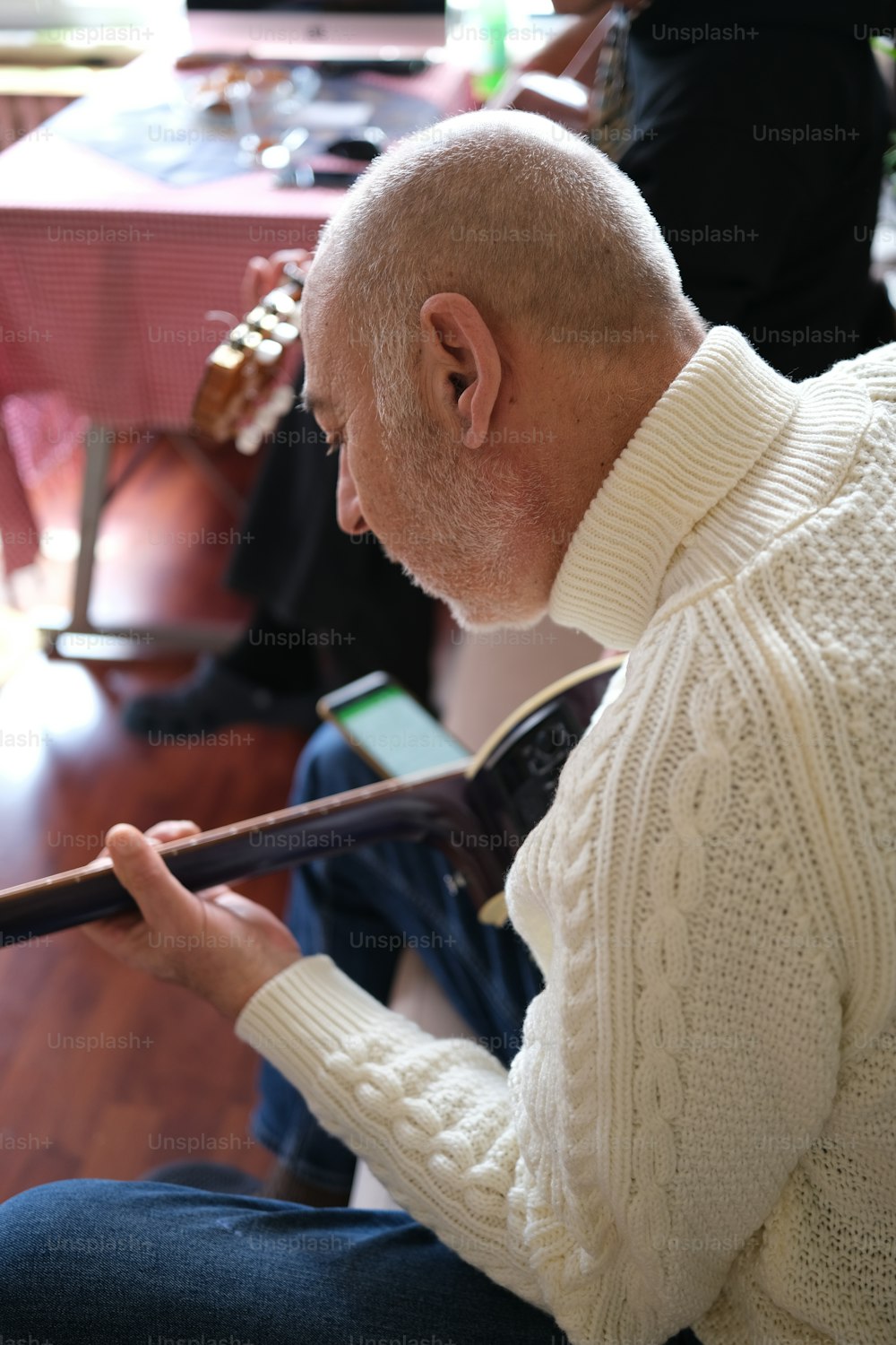 a man sitting on the floor playing a musical instrument