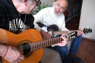 a man sitting on a couch playing a guitar