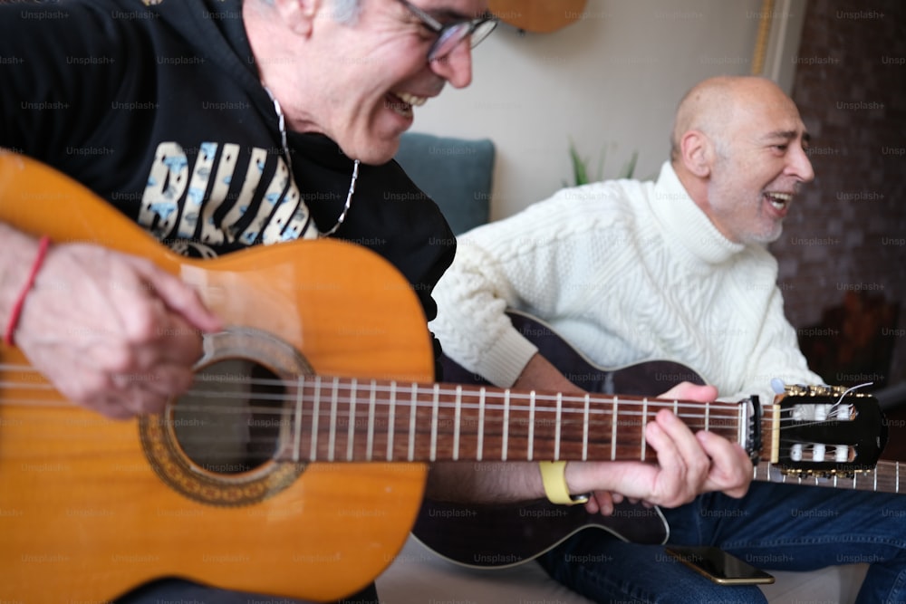 a man sitting on a couch playing a guitar