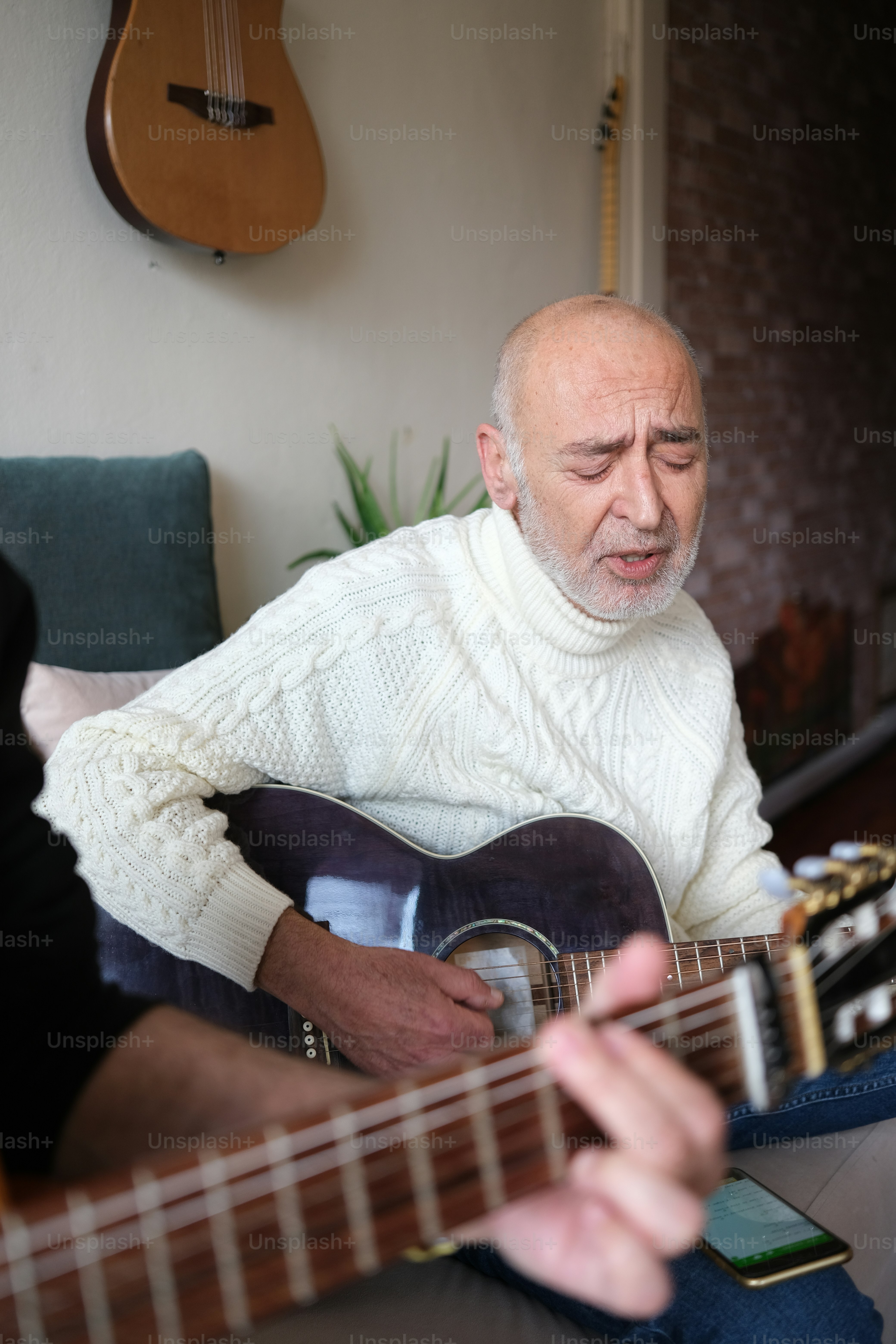 a man sitting on a couch playing a guitar
