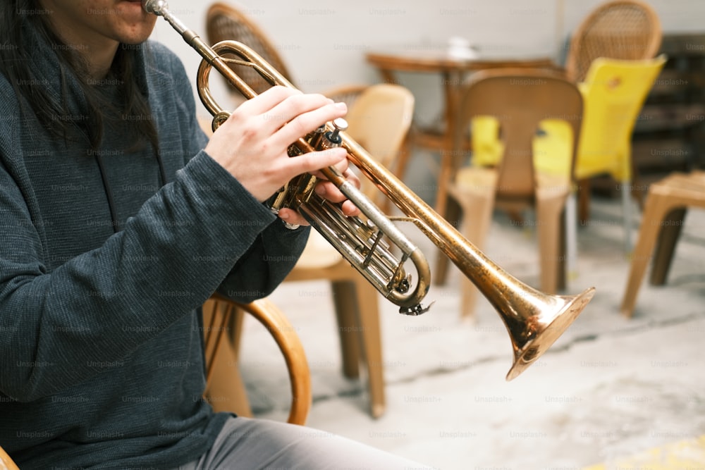 eine Person, die sich hinsetzt und Trompete spielt