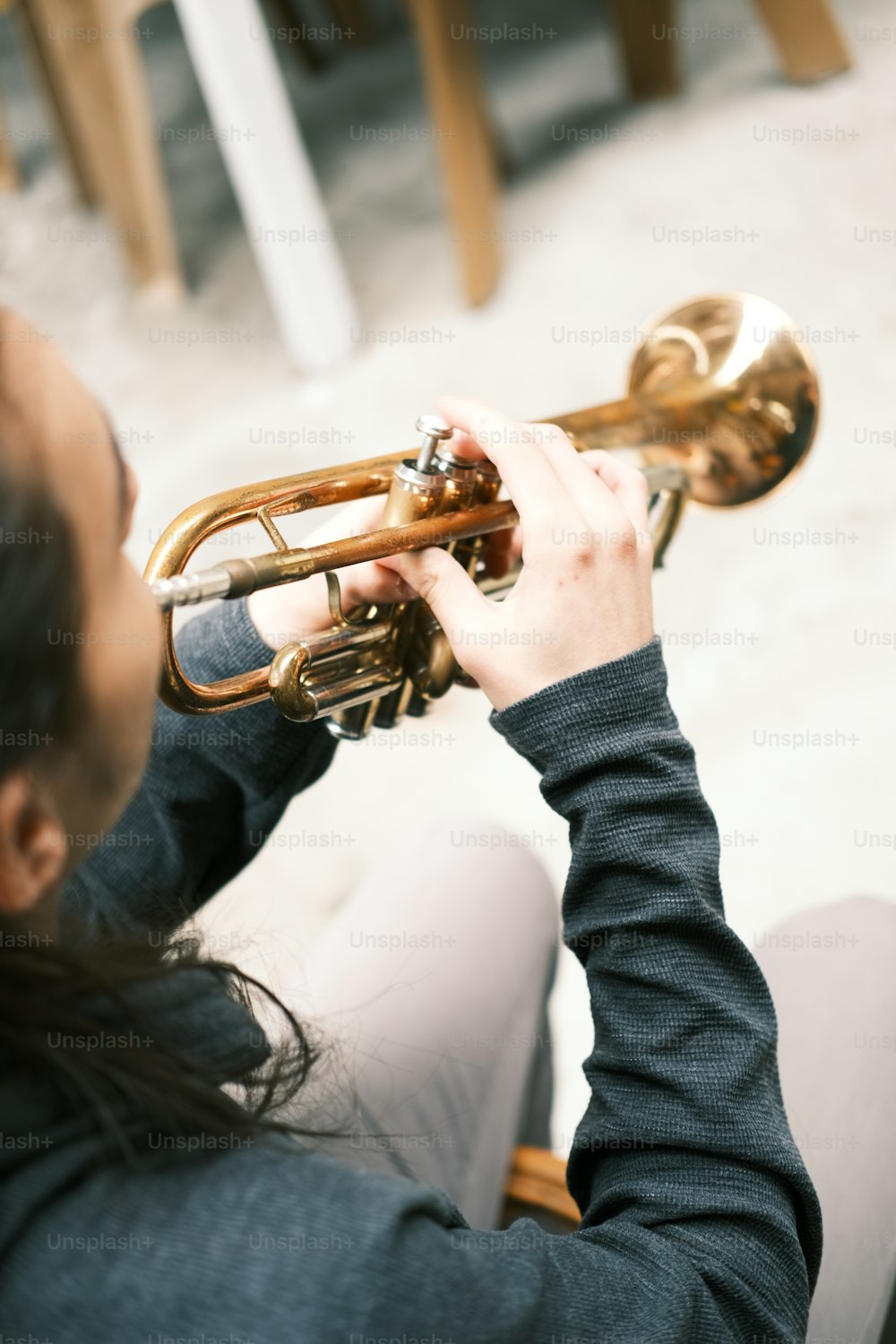 Una mujer tocando una trompeta en una sala de estar