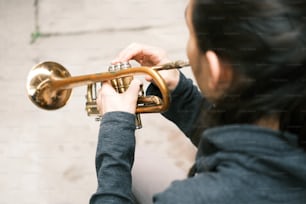 uma mulher tocando um trompete na rua