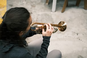 Eine Frau, die auf dem Boden Trompete spielt