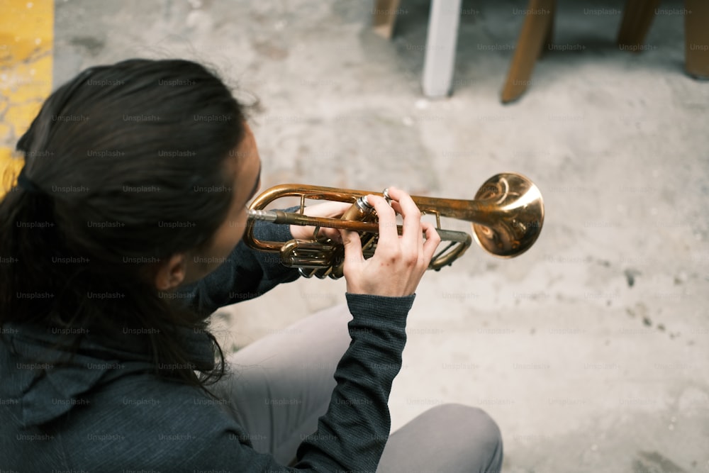 a woman playing a trumpet on the ground