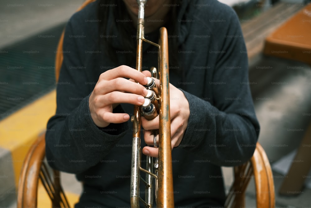 una persona sosteniendo una trompeta en sus manos