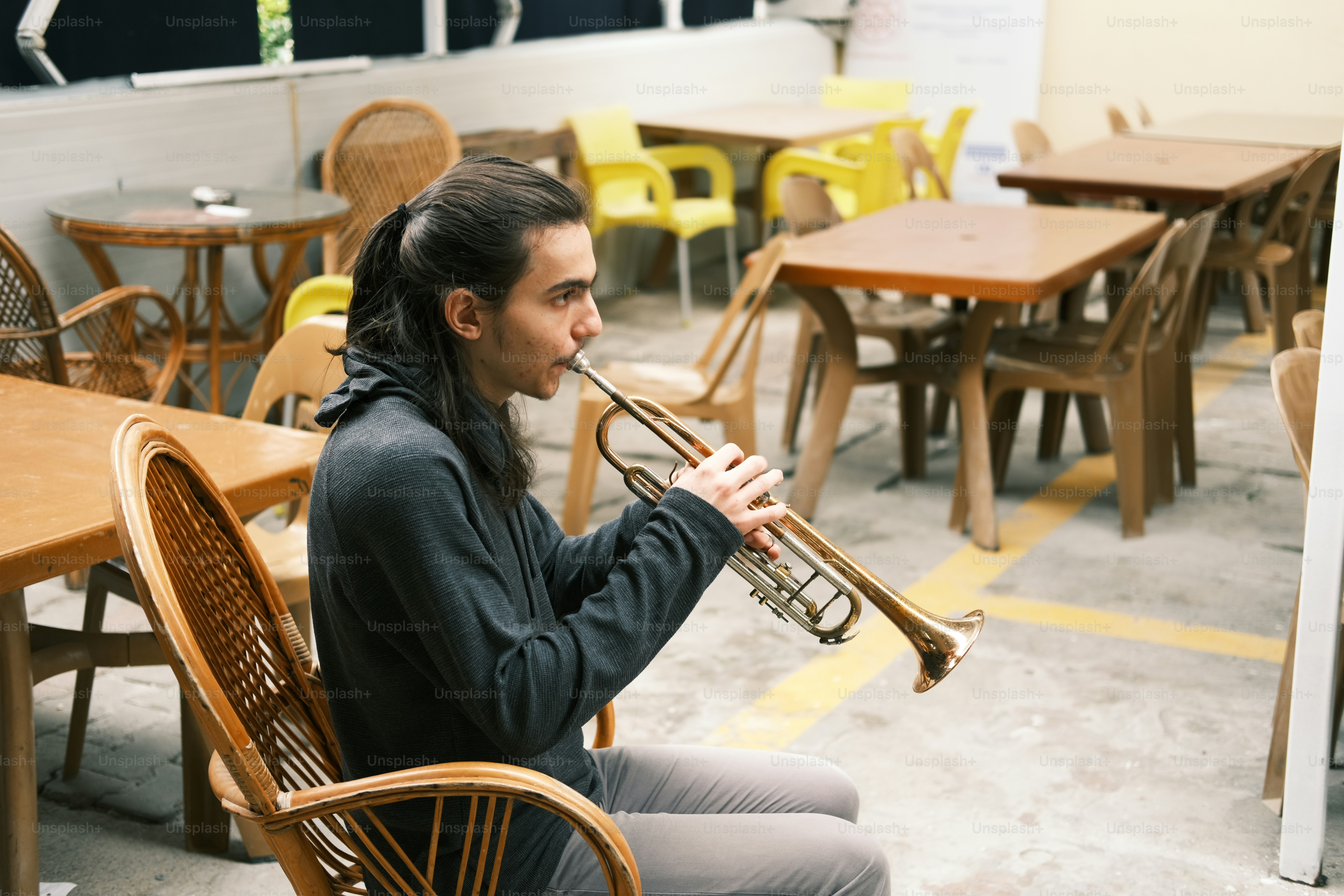 a man sitting at a table playing a trumpet