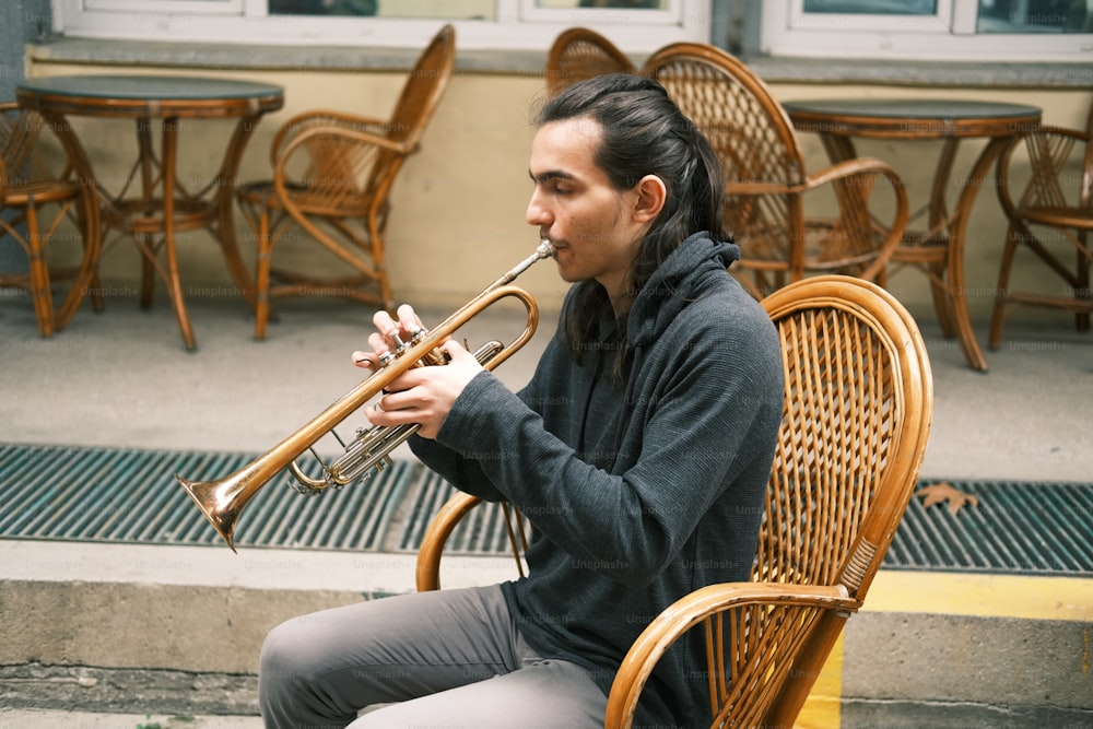 a woman sitting on a chair playing a trumpet