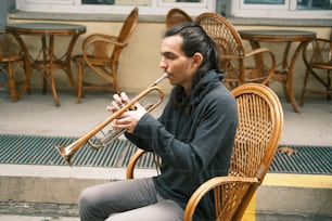 uma mulher sentada em uma cadeira tocando um trompete